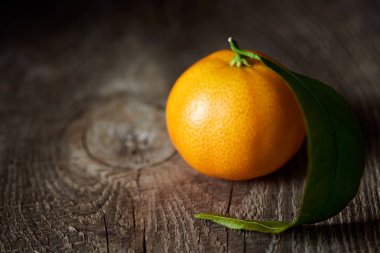 selective focus of organic tasty tangerine on wooden table  clipart