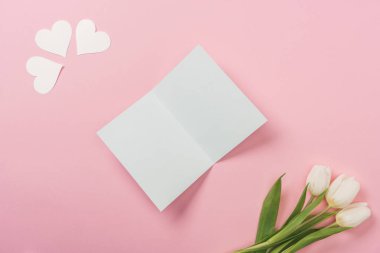 beyaz boş tebrik kartı, kağıt kalp, pembe bir arka plan üzerinde beyaz laleler