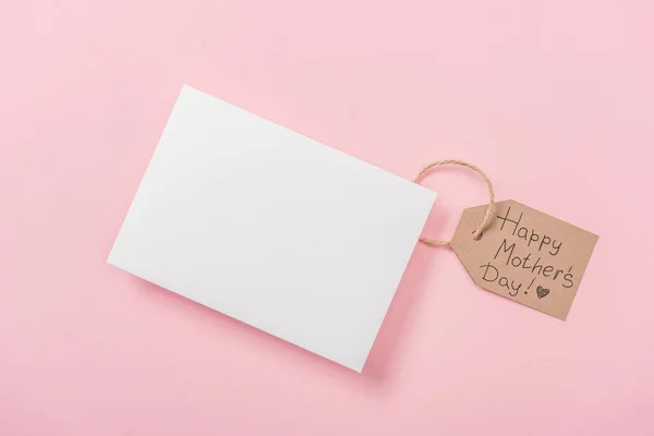 白紙のはがきとピンク背景に幸せな母の日あいさつ文を持つ木製ラベル — ストック写真