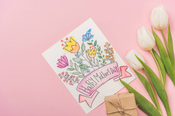 happy mothers day greeting card, gift box and white tulips on pink background