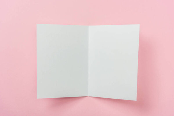 white blank greeting card on pink background with copy space