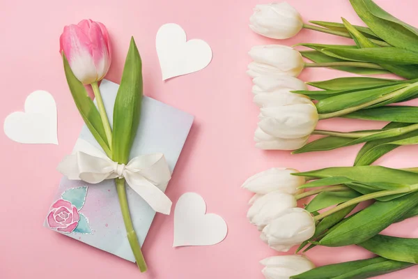 粉红色郁金香与白色弓在贺卡 纸心和白色郁金香在粉红色的背景 — 图库照片
