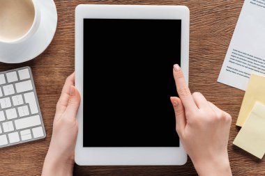 Kısmi ahşap arka plan boş ekran ile dijital tablet kullanan kadın görünümünü