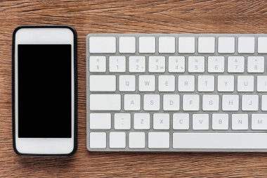 Boş ekran ve klavye ile smartphone üstten görünüm ahşap arka plan üzerinde