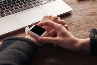 İşyerinde boş ekran ile smartwatch kullanan kadın görünümünü kırpılmış