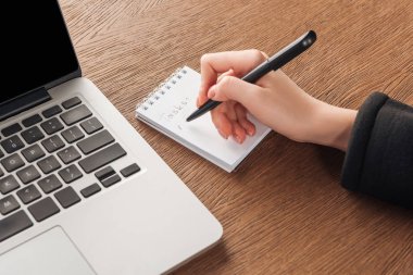Kadın defter laptop yanında yazma görünümünü kırpılmış