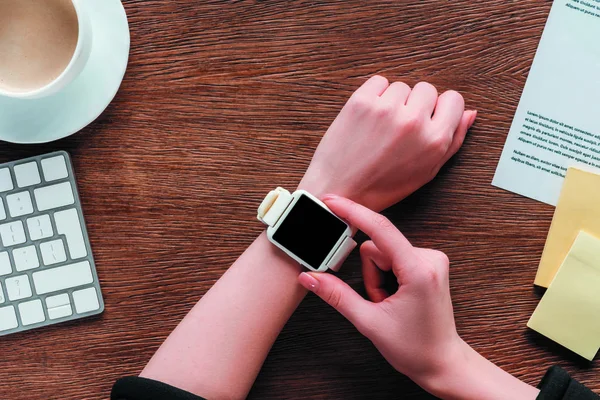 Vista Cortada Menina Usando Smartwatch Com Tela Branco Fundo Madeira — Fotografia de Stock