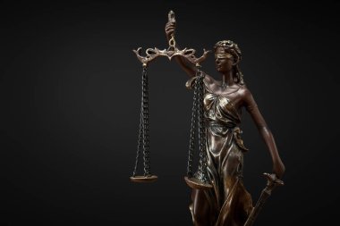 bronze statuette with scales of justice isolated on black clipart