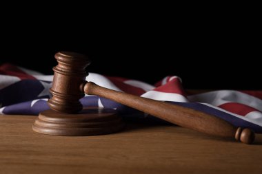 wooden gavel and american flag on table isolated on black clipart