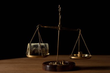 ahşap masa üstünde siyah izole ölçeklerde vintage altın para Doları banknot ve ağırlık rulo