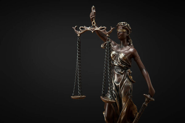 bronze statuette with scales of justice isolated on black