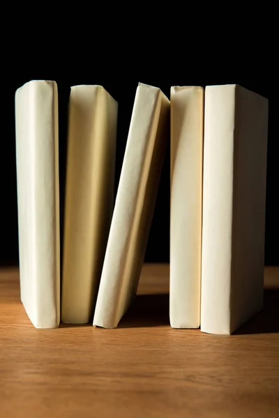Ряд Книг Белой Бумаге Чехлы Деревянный Стол Изолированы Черный — стоковое фото