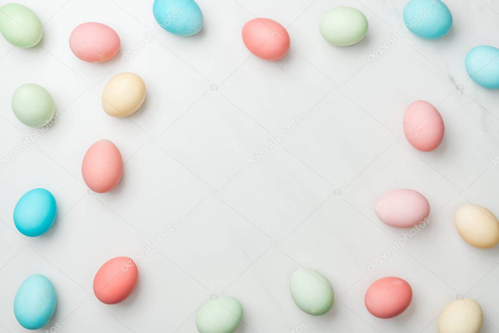 top view of frame made of pastel easter eggs on white with copy space
