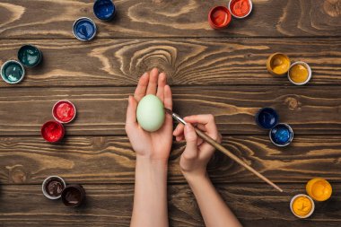 Kız Boyama Paskalya yumurta boya ile ahşap masa, üstten görünüm