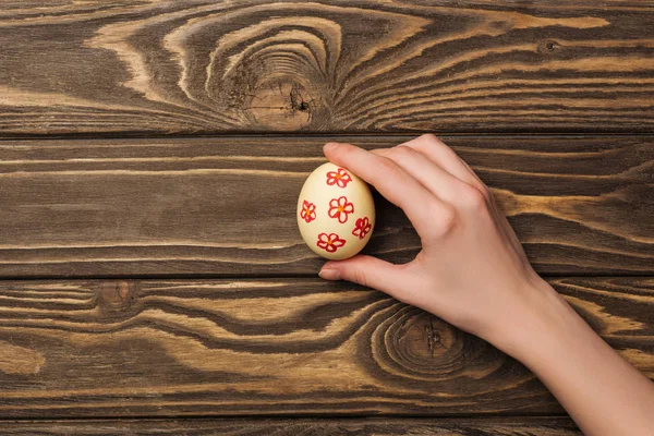 Vista Superior Mujer Sosteniendo Huevo Pascua Con Patrón Superficie Madera —  Fotos de Stock