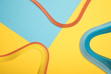 top view of curved multicolored lines on blue and yellow background clipart