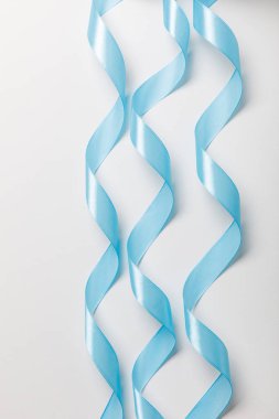 top view of blue wavy silk ribbons on grey background clipart