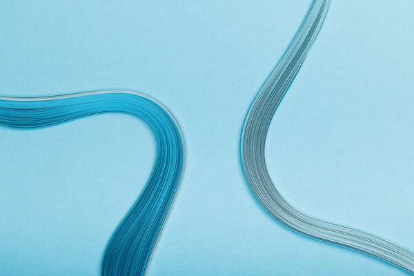 top view of blue curved abstract paper lines on blue background