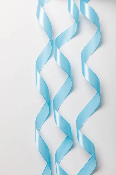 灰色の背景に青い波線シルク リボンのトップ ビュー — ストック写真