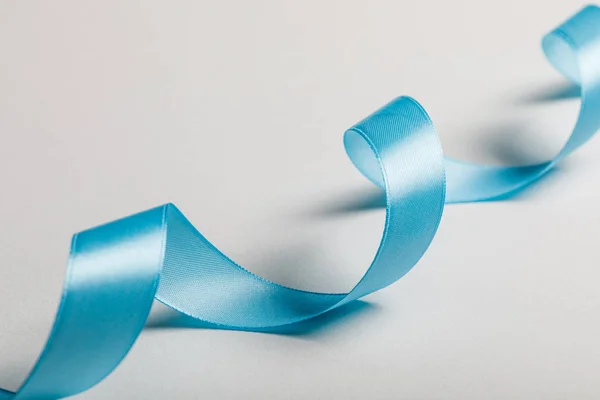 Close Curved Blue Satin Ribbon Grey Background — Stock Photo, Image