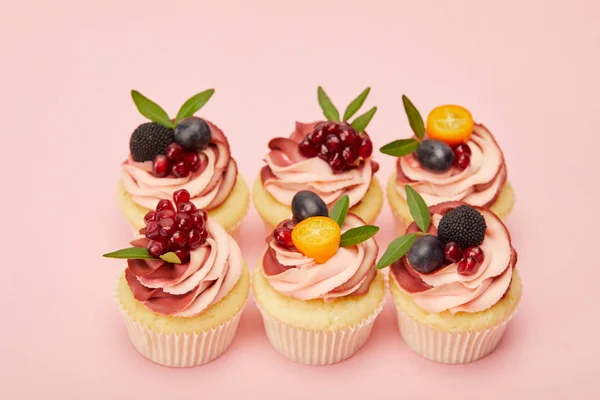 甜纸杯蛋糕与水果和浆果在粉红色的表面 — 图库照片