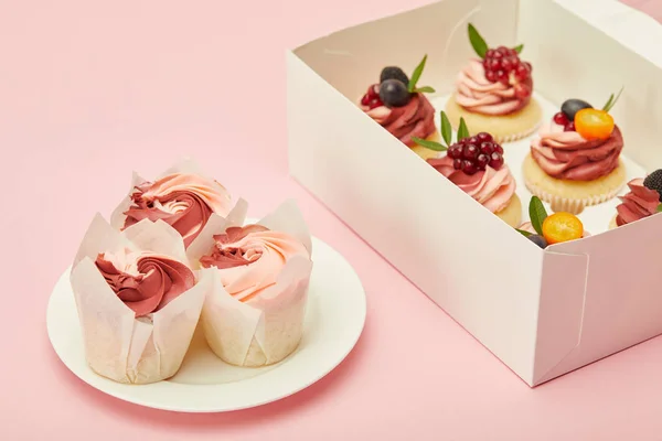 ピンクの表面に甘いカップケーキとボックスとプレート — ストック写真