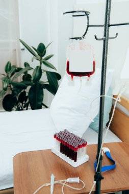 hastane koğuşunda yastık, yeşil bitki, paketlenmiş hücreler ve kan test tüpleri ile yatak