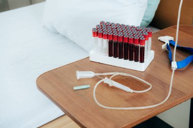 bed with pillow, blood test tubes, tourniquet and syringe in hospital ward clipart