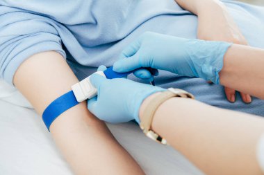 hastanede kan testi için turnike kullanan doktorun kısmi görünümü