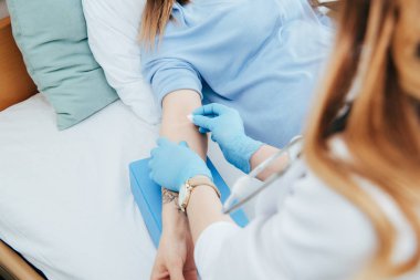 hastayı enjeksiyona hazırlayan lateks eldivenli doktorun kısmi görünümü