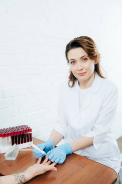 cropped view of donor and doctor obtaining blood sample clipart