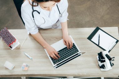 dizüstü bilgisayar kullanarak beyaz ceketli doktorun havai görünümü