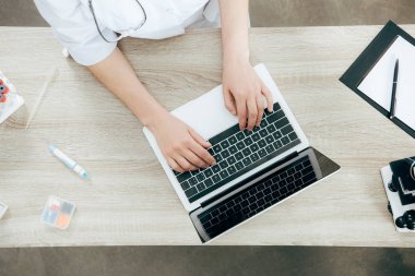 dizüstü bilgisayar kullanarak beyaz ceketli doktorun havai görünümü
