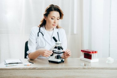klinikte mikroskop kullanarak beyaz önlük doktor