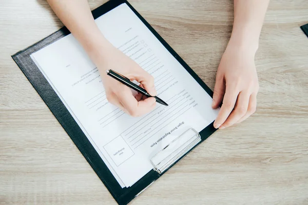 Vista Ritagliata Del Donatore Firma Modulo Registrazione Sulla Superficie Legno — Foto Stock