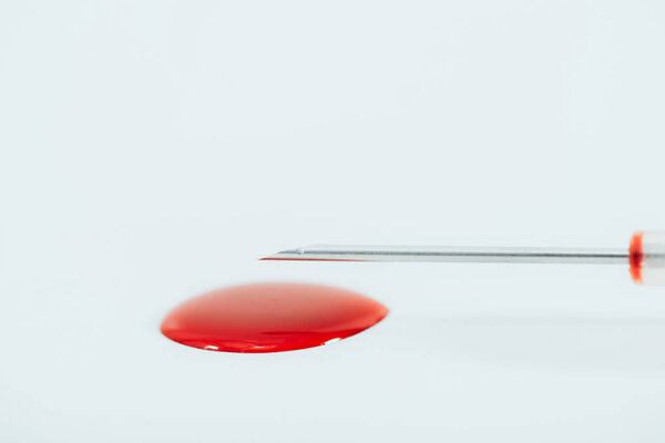 syringe needle and blood stain isolated on white