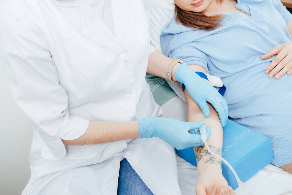 cropped view of doctor in latex gloves doing injection in hospital
