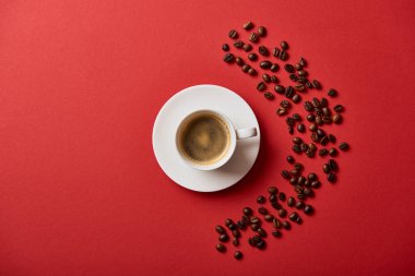 kırmızı arka planda kavrulmuş fasulye yakın fincan lezzetli kahve üst görünümü