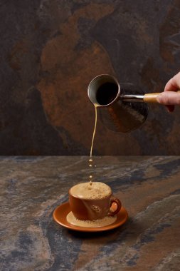 mermer yüzeyinde fincan cezve kahve döken adam kırpılmış görünümü