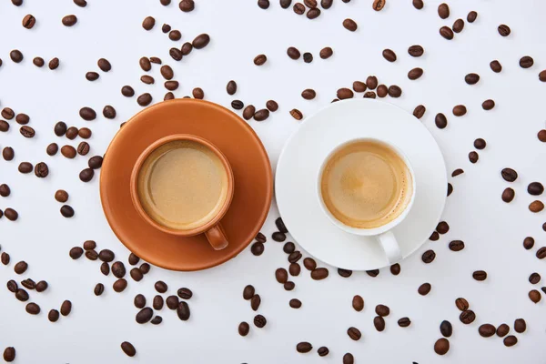 Vista Superior Del Café Tazas Blancas Marrones Platillos Cerca Granos — Foto de Stock