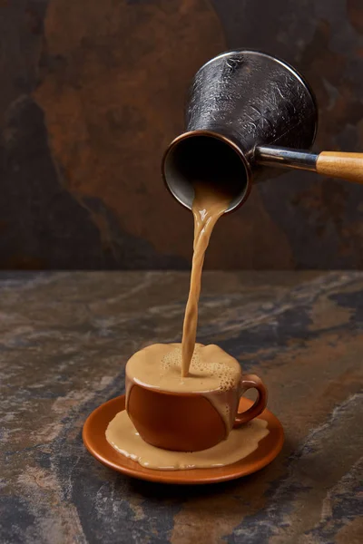 Χύνοντας Καφέ Από Μπρίκι Κύπελλο Και Πιατάκι Μαρμάρινη Επιφάνεια — Φωτογραφία Αρχείου