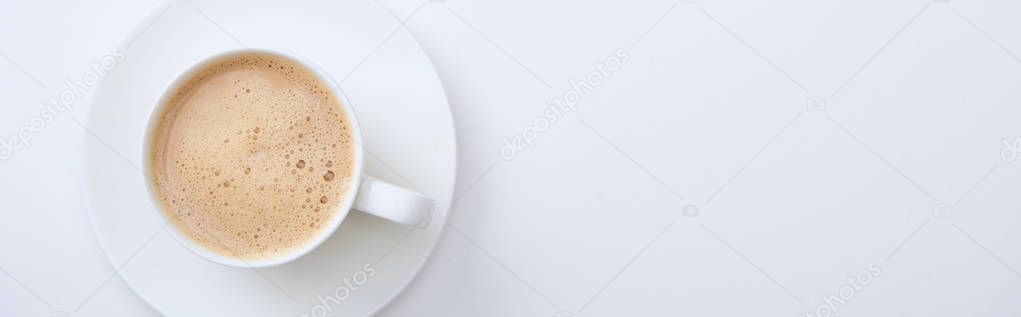 panoramic shot of white cup with delicious hot coffee on white background