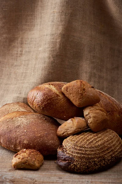 Heerlijke Broden Broodjes Houten Tafel Met Zak Achtergrond — Stockfoto