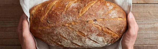 Pohled Člověka Který Drží Čerstvý Domácí Chléb Bílém Ručníku Nad — Stock fotografie