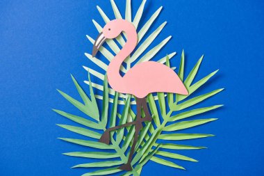 yeşil kağıt üst görünümü mavi arka plan üzerinde egzotik yaprakları ve flamingo kesilmiş