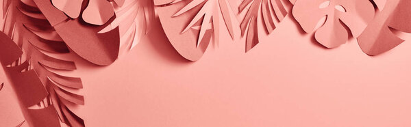 top view of paper cut palm leaves on pink background, panoramic shot