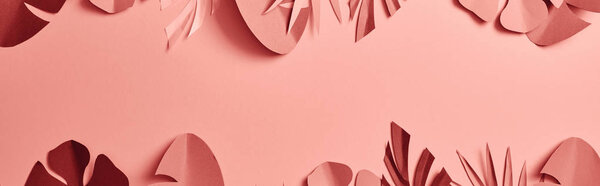 top view of paper cut palm leaves on pink background with copy space, panoramic shot