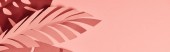 panoramic shot of paper cut palm leaves on pink background