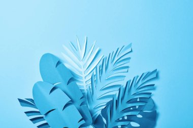 kopya alanı ile mavi arka plan üzerinde mavi minimalist kağıt kesim palmiye yaprakları demet