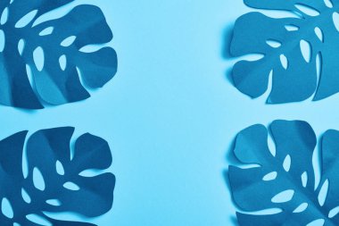 mavi minimalist kağıt kesme avuç içi üst görünümü kopya alanı ile mavi arka plan üzerinde yaprakları
